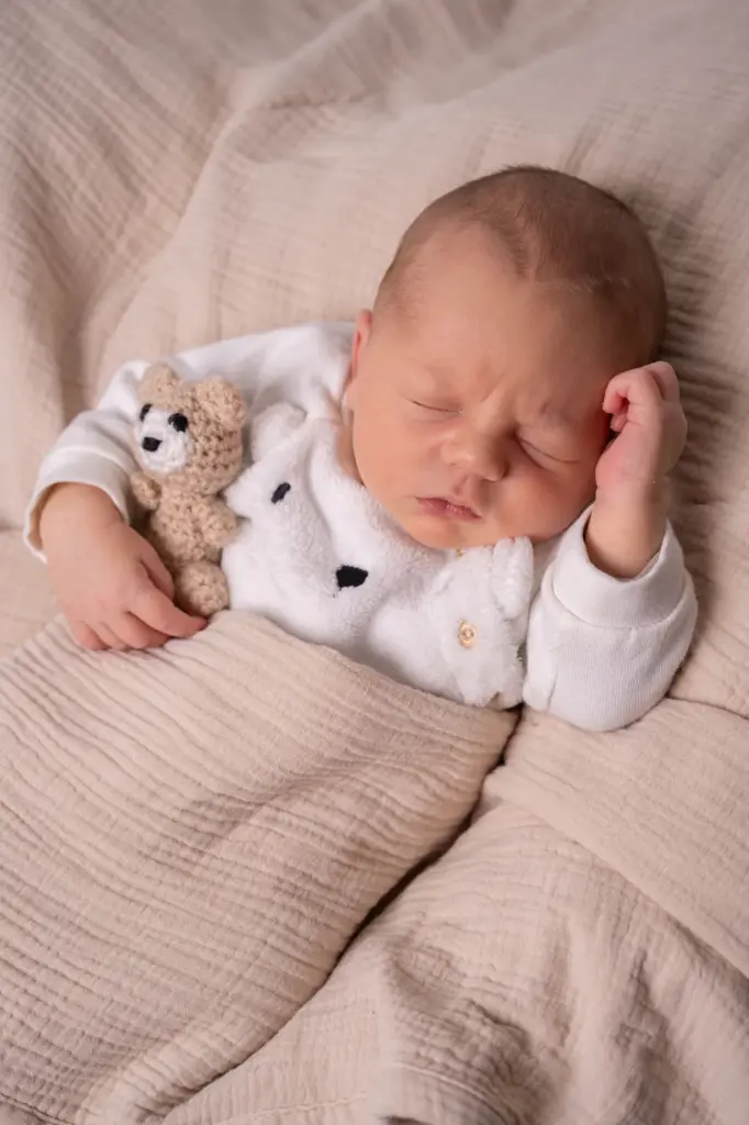 Baby liegt eingekuschelt in Decke, natürliche Babyfotos im Studio in Greding
