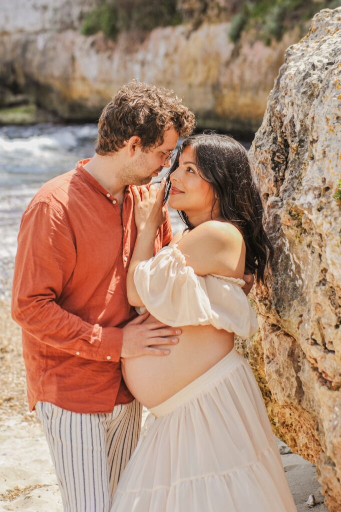 Liebevolles Paar beim Babybauchshooting an der Küste