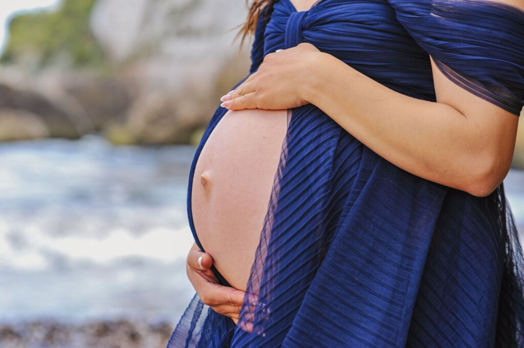 Babybauchfotografie Mallorca mit blauem Meer