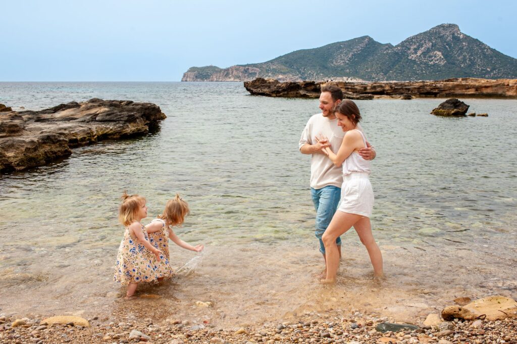 Eltern beobachten ihre spielenden Kinder am Meer
