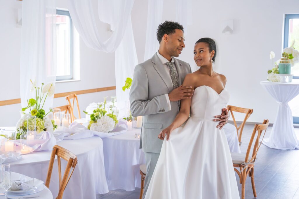 Weißes Kleid vor grüner Hochzeitsdekoration