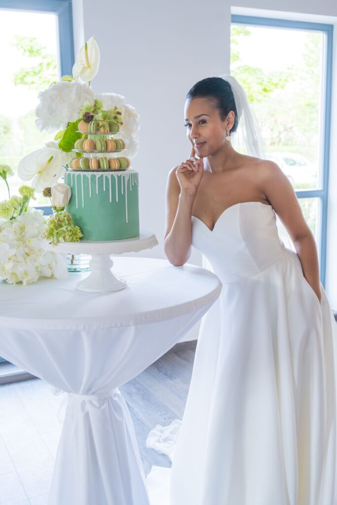 Weißes Brautkleid vor frischer grüner Tischdekoration