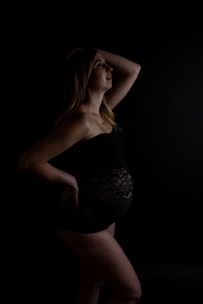 Zärtliche Umarmung während des Babybauchshootings