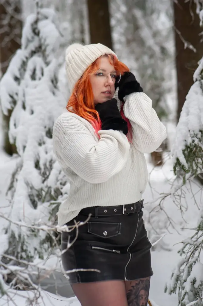 Frau in Strickpulli und Wintermütze im Schnee